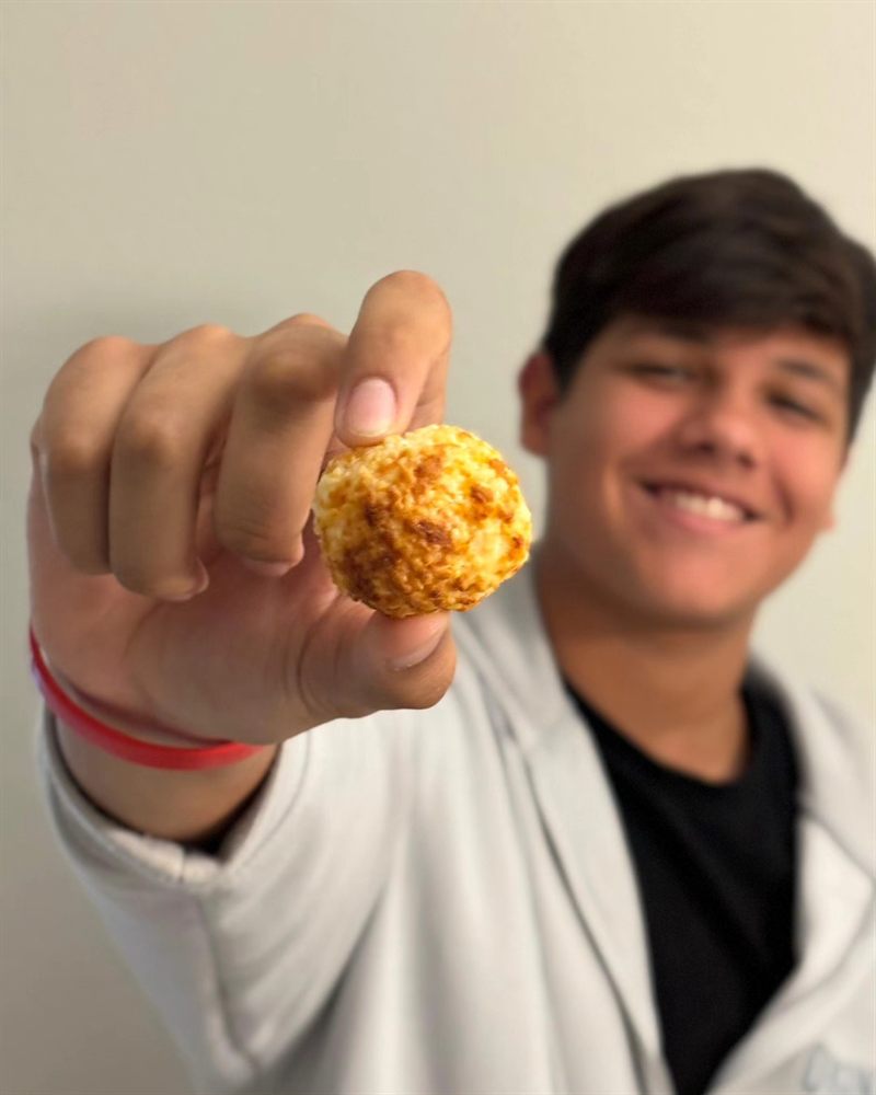 Young man showing a crispy Queijoca puff