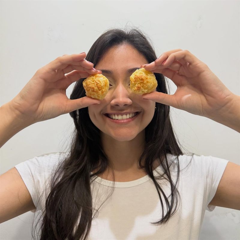 Child hands holding a bowl of Queijoca cheese puffs